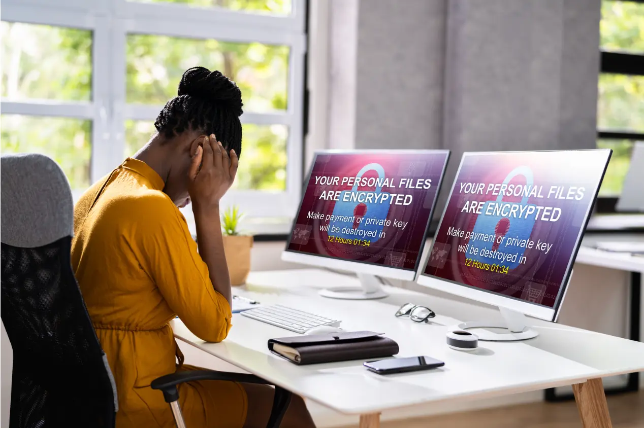 A person sitting at a desk with two computer screens